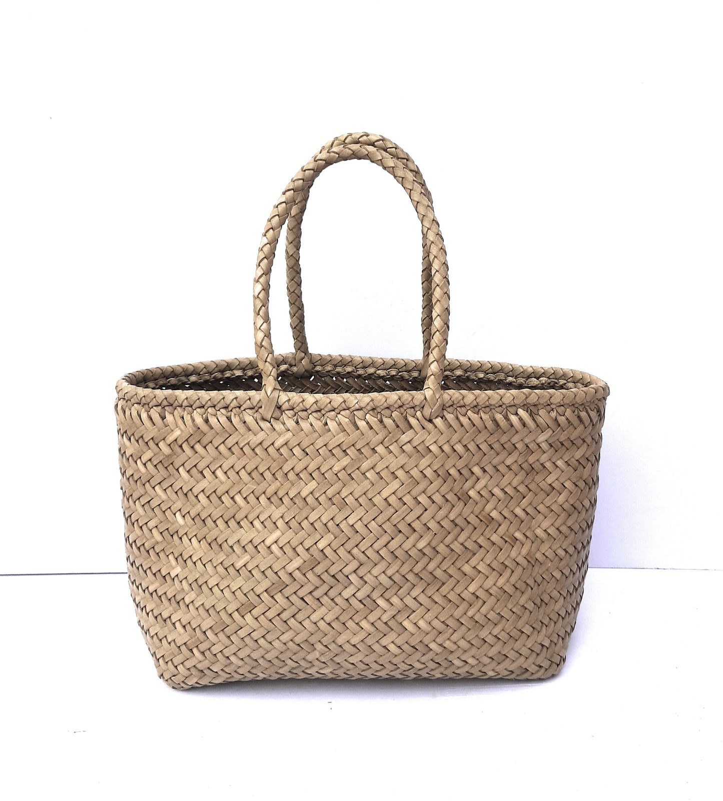 Woven leather tote bag with handles on a white background
