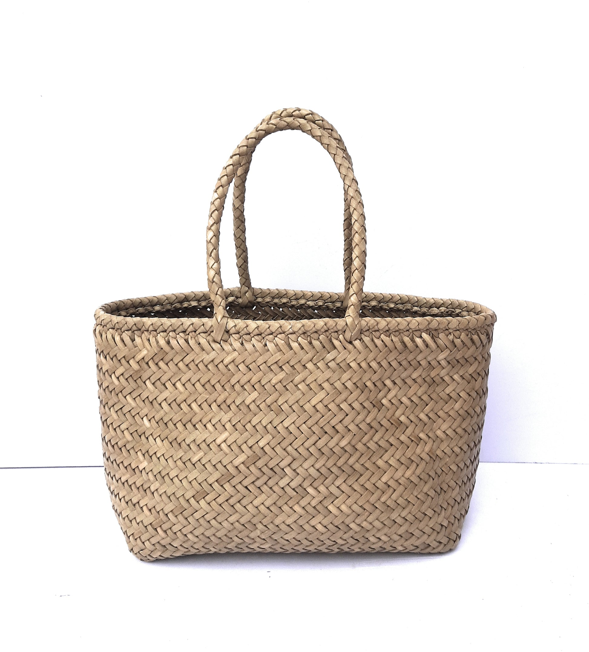 Woven leather tote bag with handles on a white background