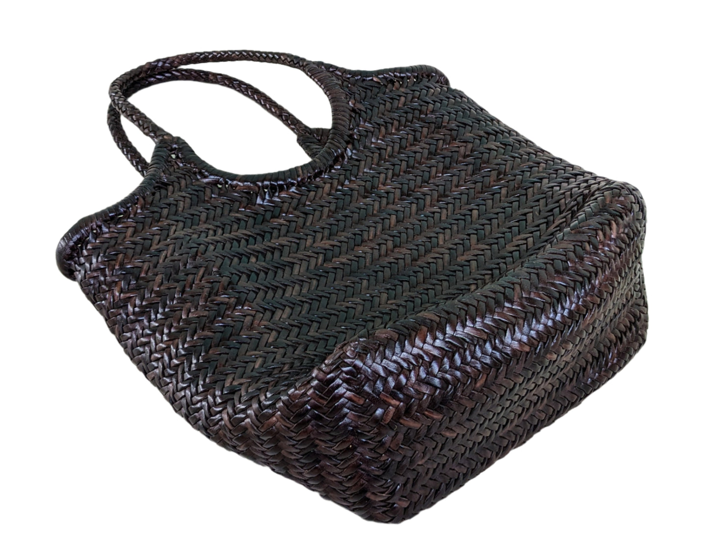 Woven leather handbag on a tiled floor with a light blue wall in the background